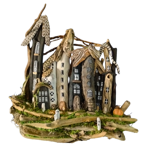 Halloween driftwood sculpture resembling a village with thatched roofs against a blue background